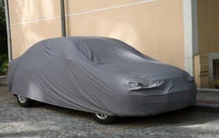 car stored with a gray cover over it