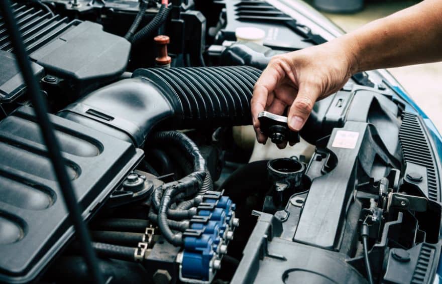 person checking fluids in their car