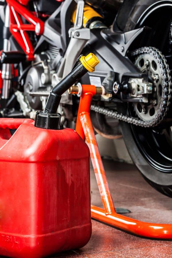 red gas can sitting next to a motorcycle